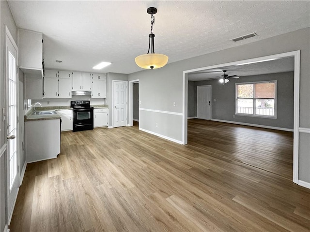 kitchen with pendant lighting, sink, white cabinets, a textured ceiling, and black / electric stove