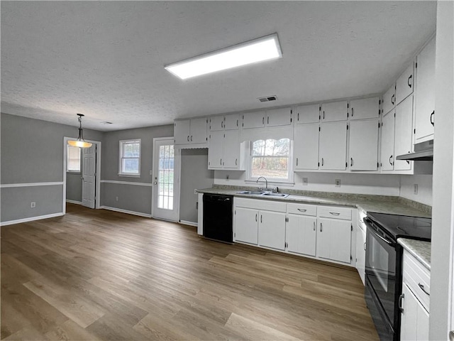 kitchen featuring white cabinetry, decorative light fixtures, and black appliances