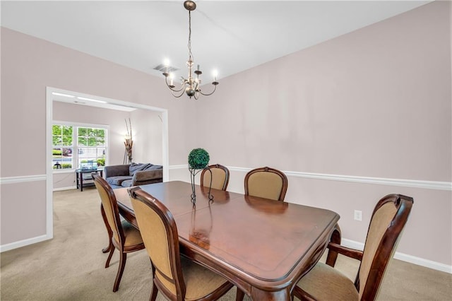 dining room with light colored carpet, baseboards, a notable chandelier, and visible vents