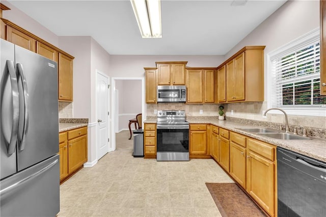 kitchen featuring backsplash, stainless steel appliances, a sink, and light countertops