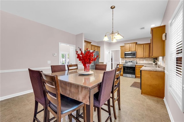 dining area with a healthy amount of sunlight, baseboards, and a chandelier
