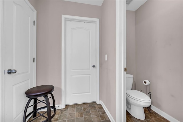 bathroom featuring baseboards and toilet
