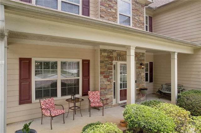 property entrance featuring covered porch and stone siding