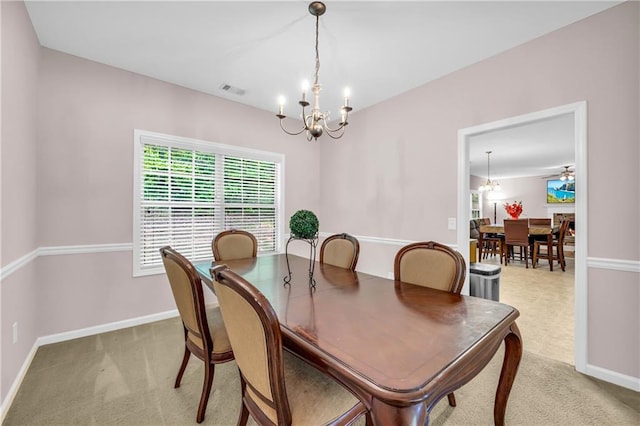 dining area featuring visible vents, baseboards, a chandelier, and light colored carpet