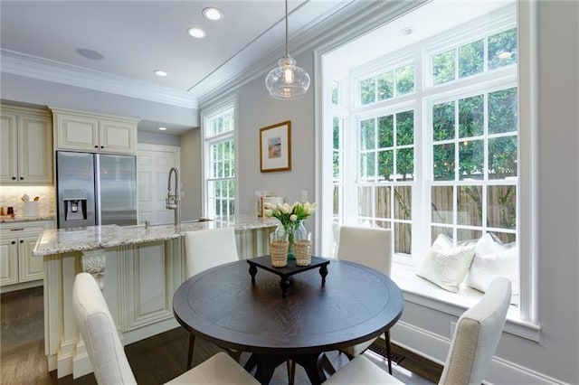 dining area with dark hardwood / wood-style flooring, ornamental molding, and sink