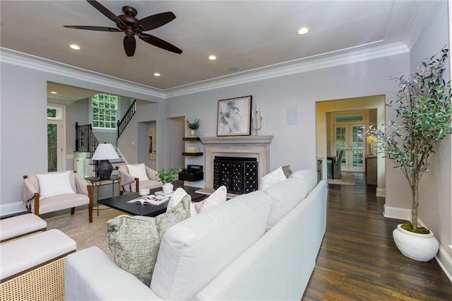 living room featuring dark hardwood / wood-style floors, ceiling fan, and crown molding