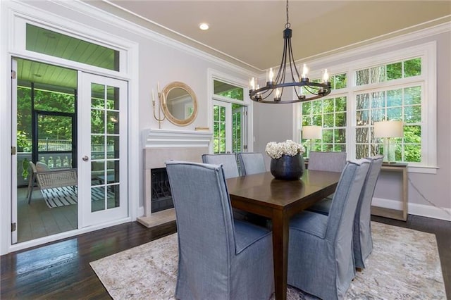 dining room with french doors, dark wood-type flooring, ornamental molding, and a notable chandelier