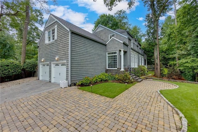 exterior space featuring a garage and a front lawn