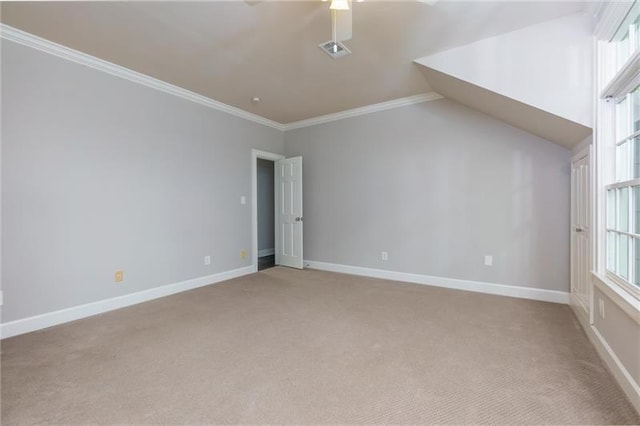 empty room with ceiling fan, crown molding, lofted ceiling, and light carpet