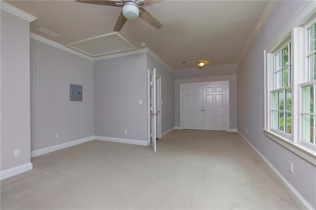 carpeted spare room with ceiling fan, crown molding, and electric panel