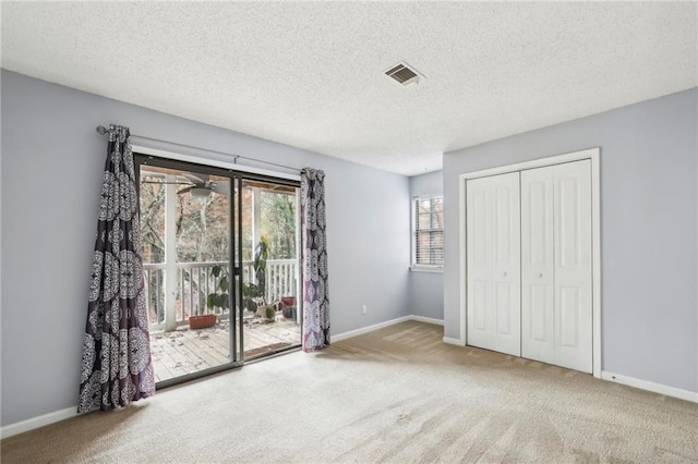 511 Barrington Hills Dr, Atlanta, GA 30350 - unfurnished bedroom with access to exterior, carpet floors, baseboards, a textured ceiling, and a closet