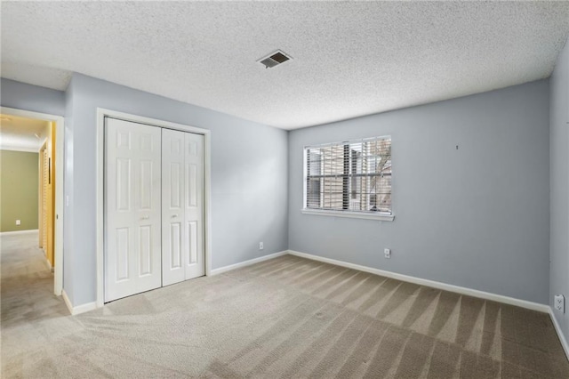 511 Barrington Hills Dr, Atlanta, GA 30350 - unfurnished bedroom with carpet floors, a closet, baseboards, and a textured ceiling