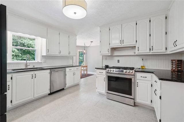 kitchen featuring white cabinetry, sink, a textured ceiling, light tile patterned flooring, and appliances with stainless steel finishes