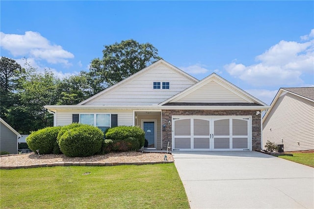 view of front of home featuring an attached garage, concrete driveway, and a front lawn