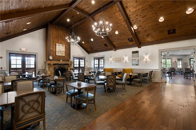 living area with beamed ceiling, high vaulted ceiling, a stone fireplace, and wooden ceiling
