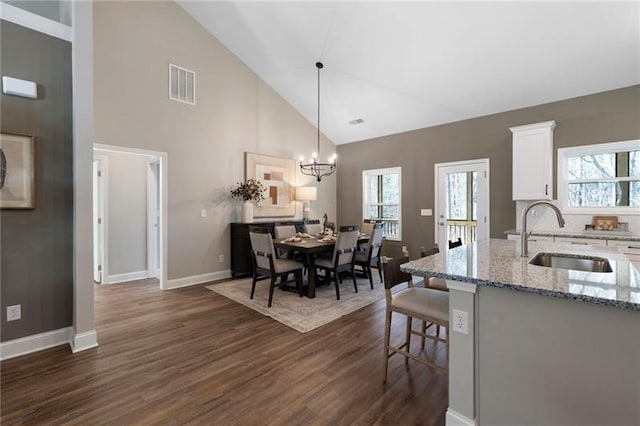 interior space featuring dark wood-style floors, visible vents, a wealth of natural light, and baseboards