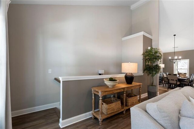 living room with baseboards, a notable chandelier, wood finished floors, and high vaulted ceiling