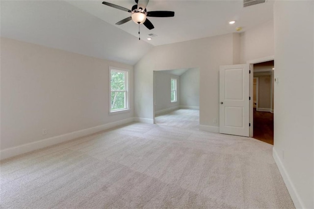 interior space with lofted ceiling, recessed lighting, light colored carpet, and baseboards