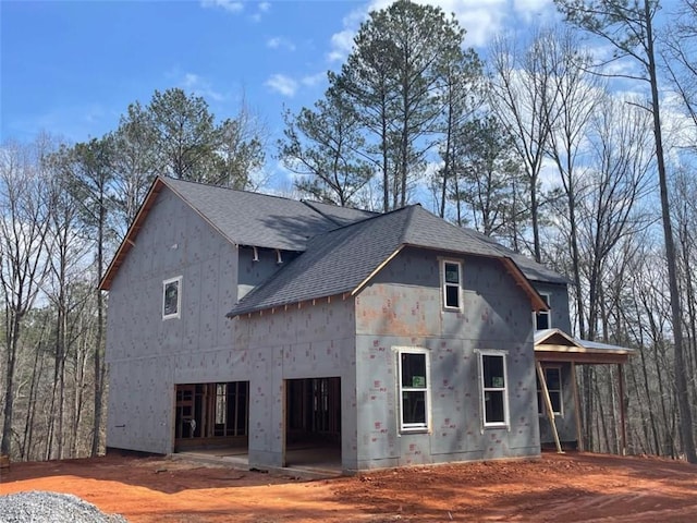 view of side of home with a shingled roof