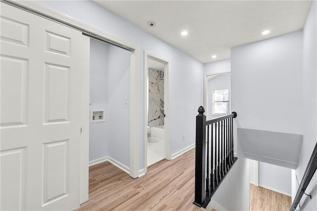 hallway with light hardwood / wood-style floors