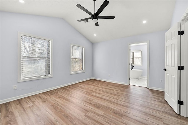 unfurnished bedroom featuring lofted ceiling, ensuite bath, ceiling fan, and light hardwood / wood-style floors