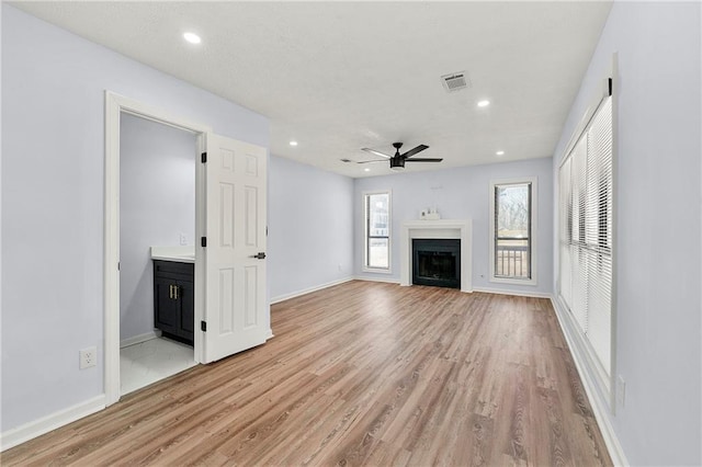 unfurnished living room featuring light wood-type flooring and ceiling fan