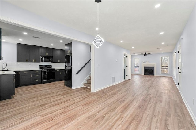 living room with sink, ceiling fan, and light hardwood / wood-style flooring