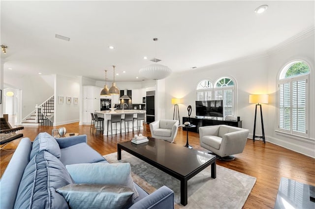 living room with light hardwood / wood-style flooring and crown molding