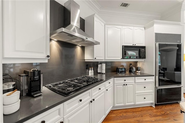 kitchen with white cabinets, wall chimney exhaust hood, dark wood-type flooring, black appliances, and crown molding