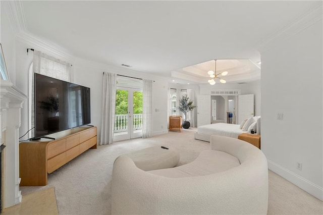 living room with a tile fireplace, a notable chandelier, light colored carpet, a raised ceiling, and ornamental molding