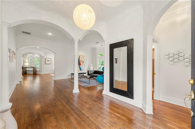 entrance foyer with hardwood / wood-style flooring, crown molding, and ornate columns