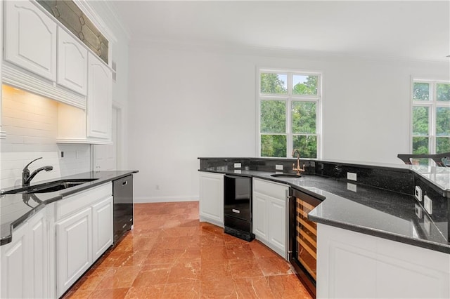 kitchen with white cabinets, beverage cooler, sink, and black dishwasher