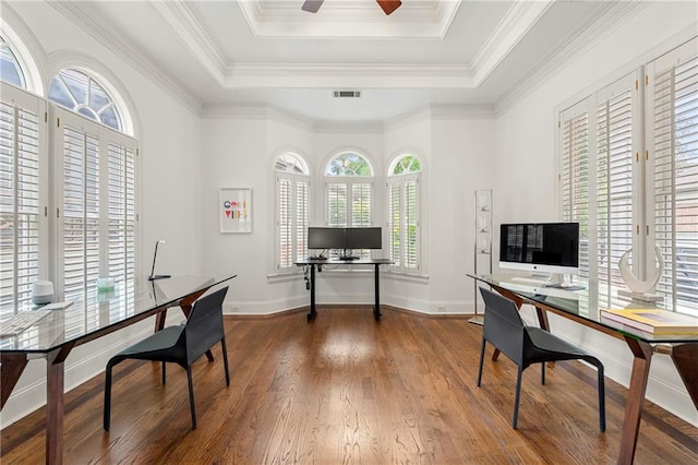 home office with ceiling fan, hardwood / wood-style flooring, a raised ceiling, and ornamental molding