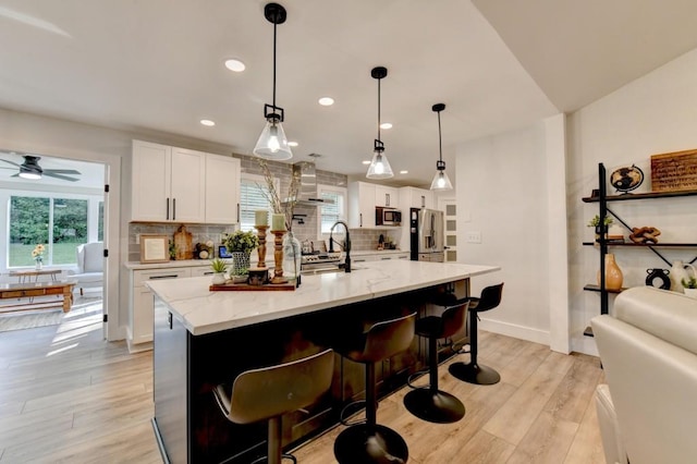 5441 E Main St, Flowery Branch, GA 30542 - kitchen with stainless steel appliances, backsplash, white cabinets, light wood-type flooring, and recessed lighting