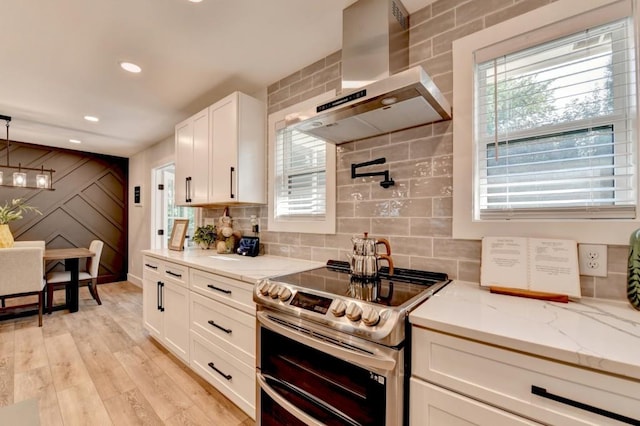5441 E Main St, Flowery Branch, GA 30542 - kitchen featuring range with two ovens, wall chimney exhaust hood, white cabinets, light wood-type flooring, and light stone countertops