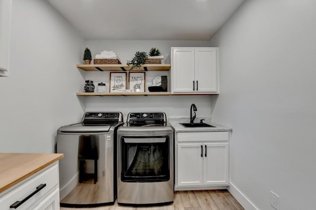 5441 E Main St, Flowery Branch, GA 30542 - laundry area with washer and clothes dryer, light wood finished floors, and cabinet space