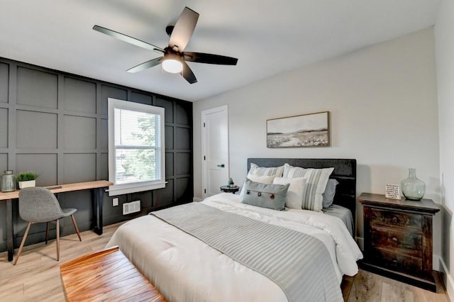 5441 E Main St, Flowery Branch, GA 30542 - bedroom featuring light wood-type flooring, a decorative wall, a desk, and ceiling fan