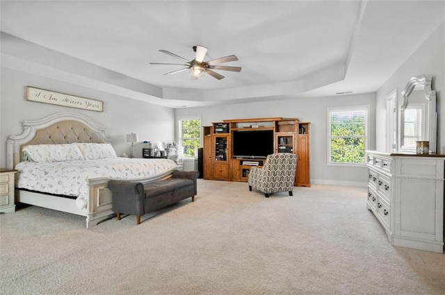 bedroom featuring a tray ceiling, ceiling fan, and light colored carpet