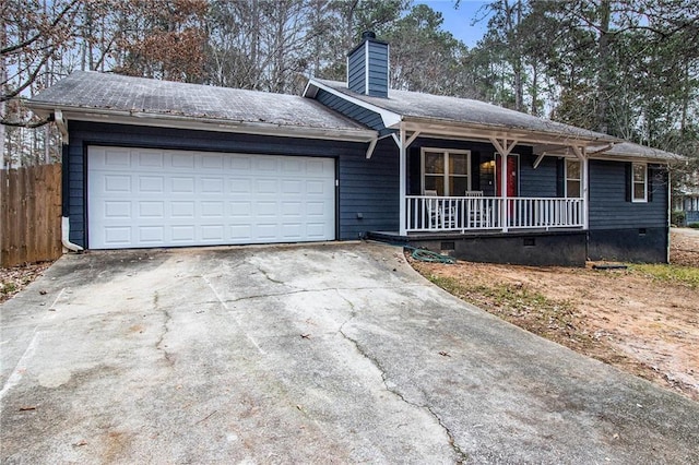 ranch-style house featuring covered porch and a garage