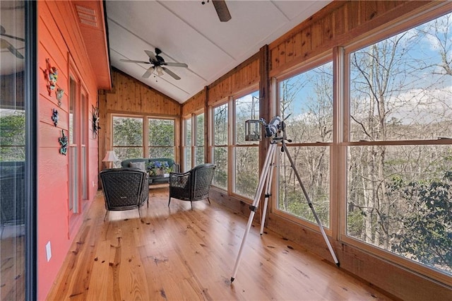 unfurnished sunroom with lofted ceiling and a ceiling fan