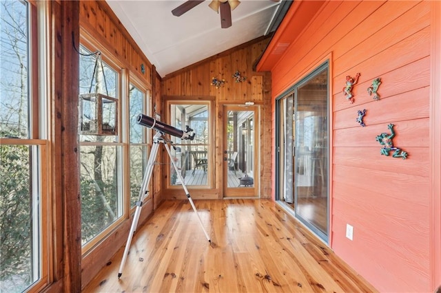 unfurnished sunroom with lofted ceiling, ceiling fan, and a wealth of natural light