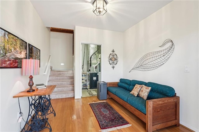 living area featuring stairs, wood-type flooring, and baseboards