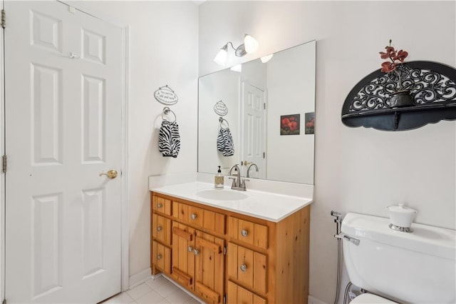 bathroom with toilet, tile patterned flooring, and vanity