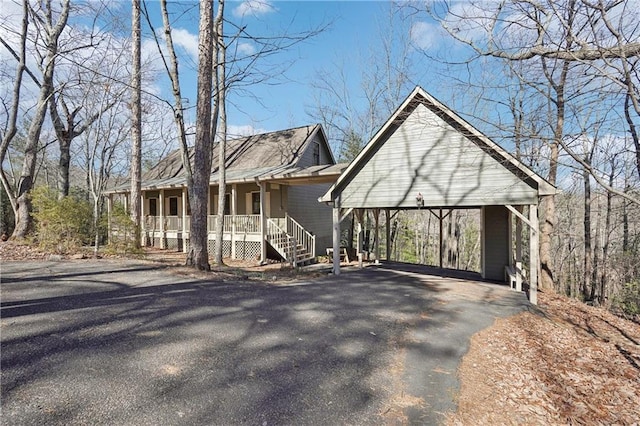 view of front of property featuring a porch, a detached carport, and driveway