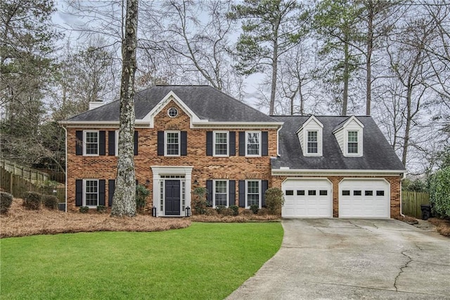 colonial inspired home with a garage and a front yard