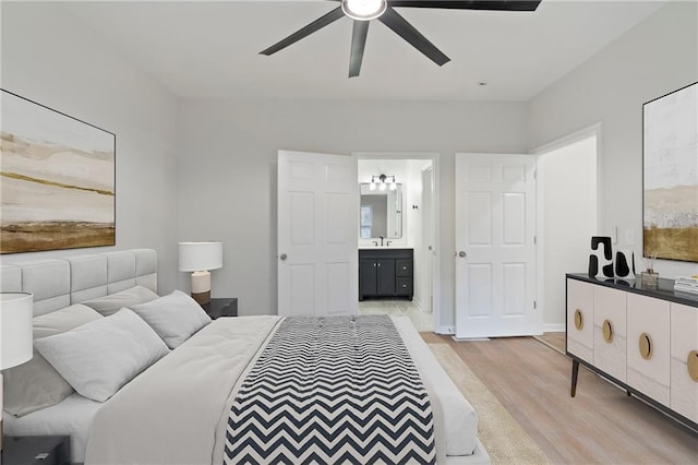 bedroom featuring ceiling fan, connected bathroom, sink, and light wood-type flooring