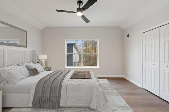 bedroom with ceiling fan, lofted ceiling, hardwood / wood-style floors, and a closet