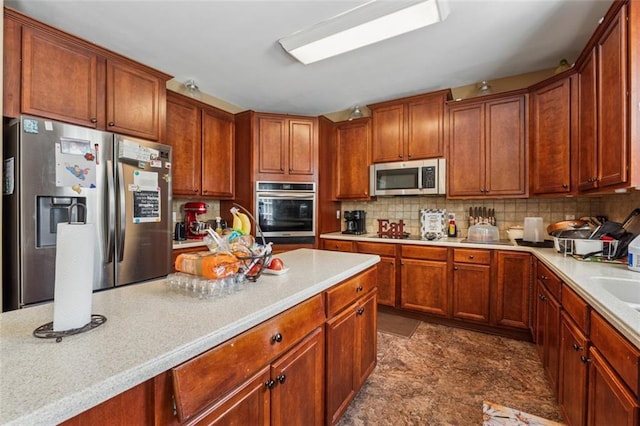 kitchen with appliances with stainless steel finishes, light countertops, and tasteful backsplash