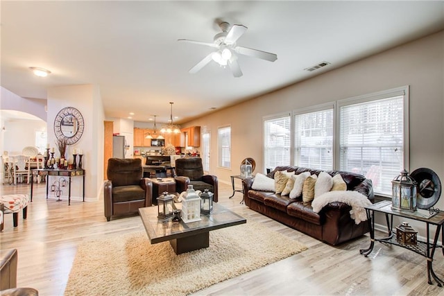 3258 Kessock Ridge Trl, Snellville, GA 30039 - living room featuring arched walkways, ceiling fan, light wood-type flooring, and a chandelier