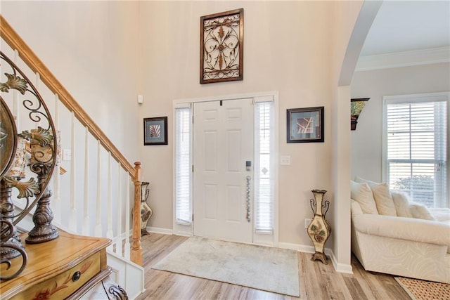 3258 Kessock Ridge Trl, Snellville, GA 30039 - entryway featuring arched walkways, light wood finished floors, stairway, and crown molding